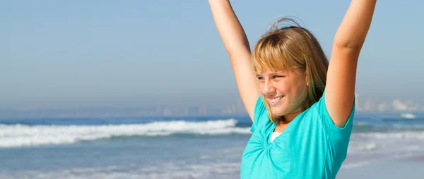 Teen girl with open arms on beach — Stock Photo, Image