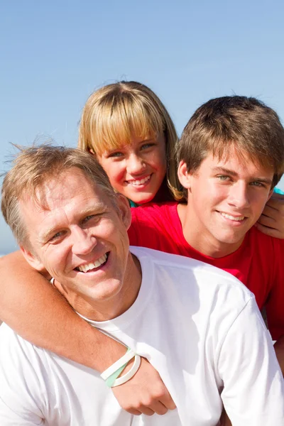 Happy mid age father and children on beach — Stock Photo, Image