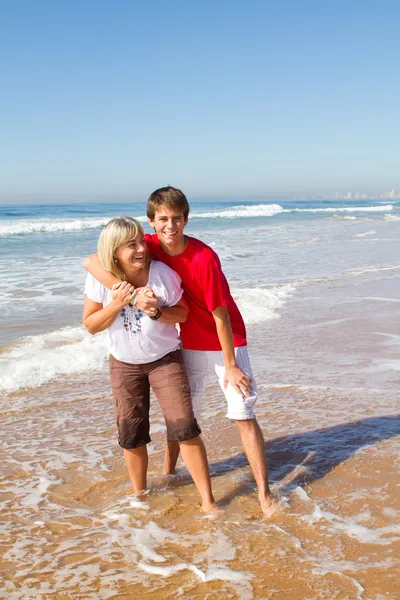 Orta yaşlı anne ve genç oğlu Beach — Stok fotoğraf
