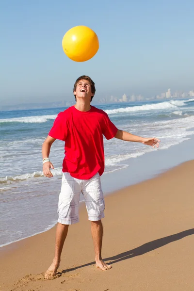 Adolescente menino jogando bola de praia na praia — Fotografia de Stock