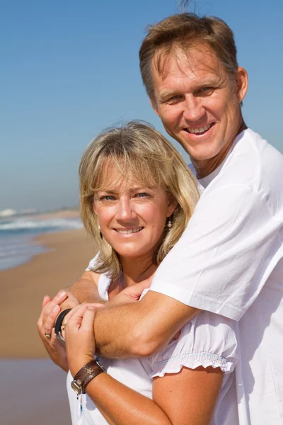 Feliz casal maduro abraçando na praia — Fotografia de Stock