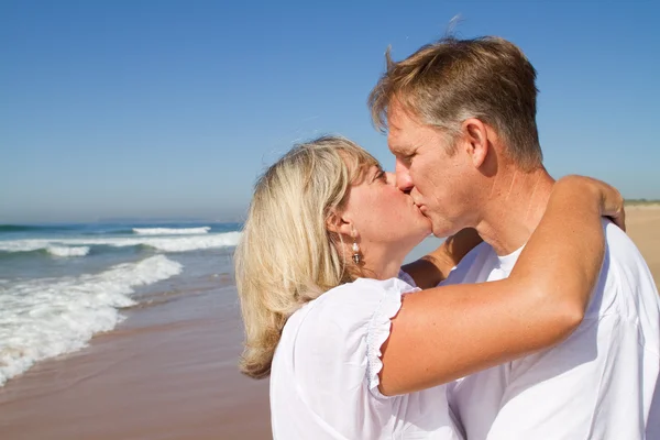 中间老年的夫妇在海滩上接吻 — 图库照片