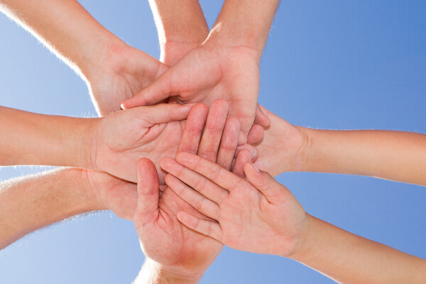 hands together with blue sky above