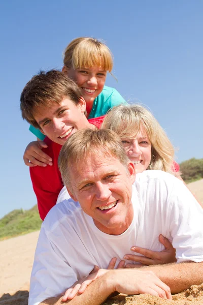 Famiglia felice sdraiata sulla spiaggia — Foto Stock
