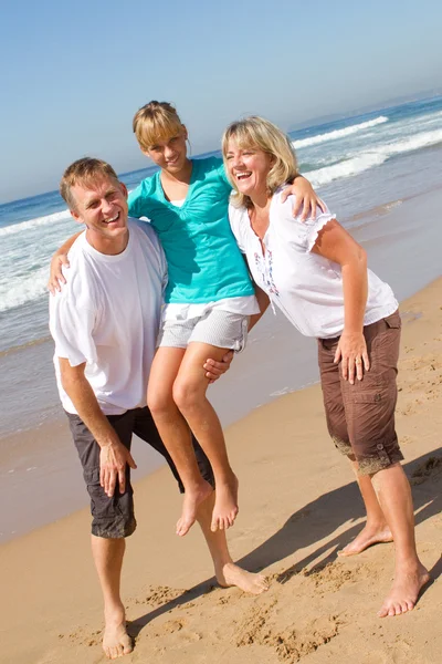 Родители забирают дочь на пляже — стоковое фото