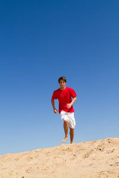 Adolescente ativo menino correndo na praia — Fotografia de Stock