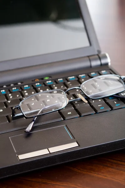 Γυαλιά σε μαύρο φορητό υπολογιστή — Φωτογραφία Αρχείου