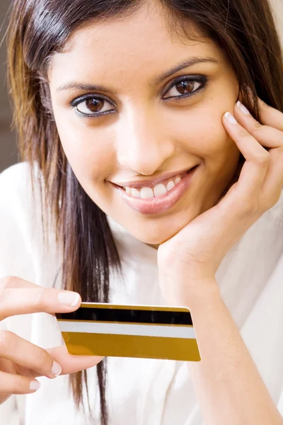 Beautiful young woman holding a credit card and smiling — Stock Photo, Image