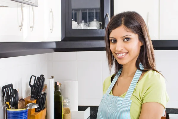 Jovem dona de casa na cozinha com avental — Fotografia de Stock