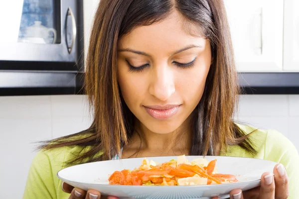 Vrouw ruiken warm eten in keuken — Stockfoto
