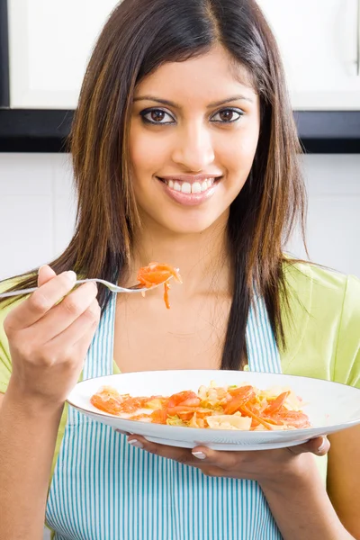 Jovem mulher degustação de alimentos na cozinha — Fotografia de Stock