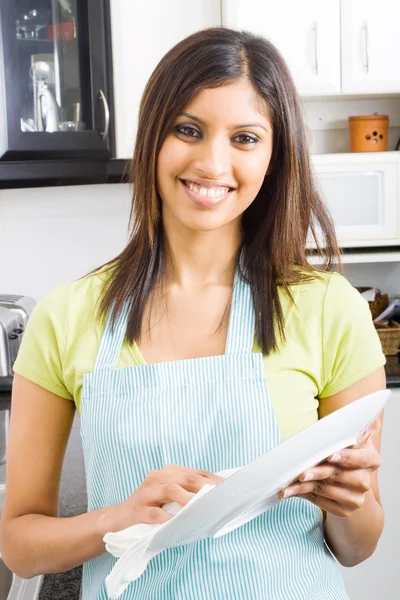 台所で料理を乾燥させる若い女性 — ストック写真