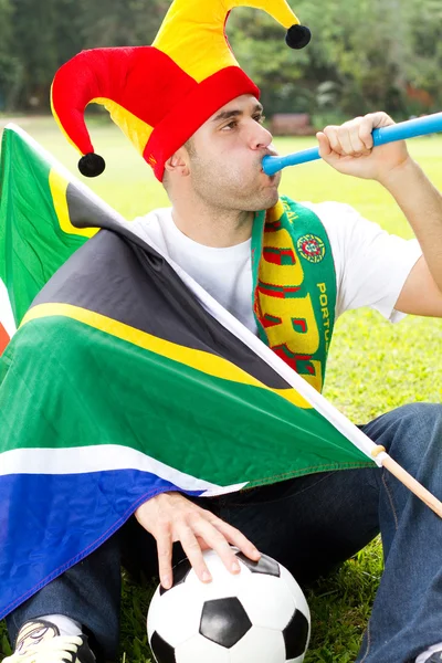 Soccer fan blowing a vuvuzela — Stock Photo, Image