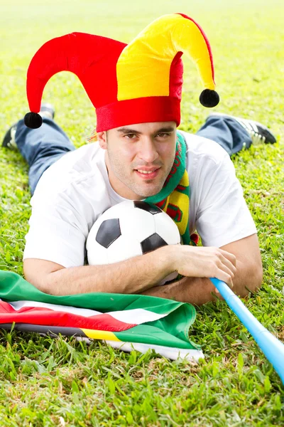 Fanático del fútbol acostado en hierba verde — Foto de Stock