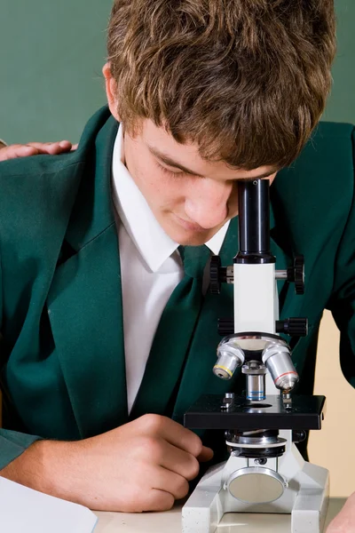Μαθητής γυμνασίου χρησιμοποιώντας μικροσκόπιο — Φωτογραφία Αρχείου