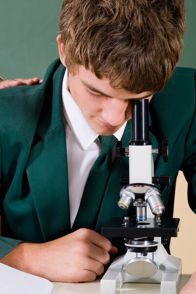 High school student using microscope