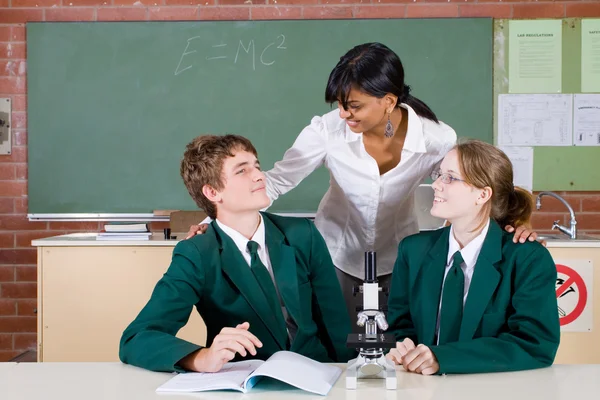 Teacher talking to students in science class — Stock Photo, Image