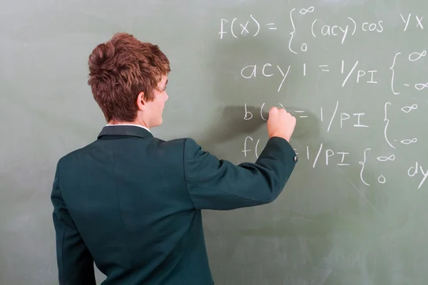 High school student write on blackboard — Stockfoto