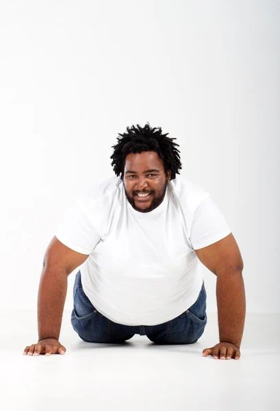 Смешной толстый африканский мужчина лежит на полу — стоковое фото
