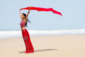 Indianerin hält Sari am windigen Strand