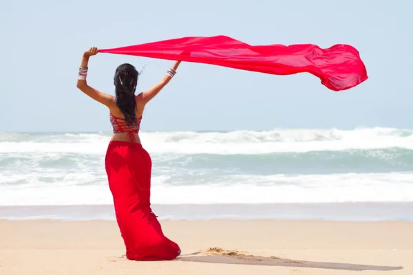 Rüzgarlı sahilde bir Malaya peştemâli tutan genç kadın — Stok fotoğraf