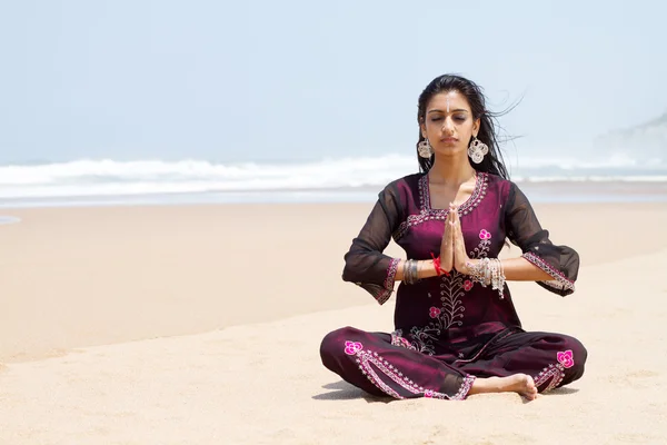 Indian woman in traditional clothing on beach meditation — Stock Photo, Image