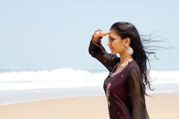 Молода індійська жінка на пляжі дивиться на океан — стокове фото