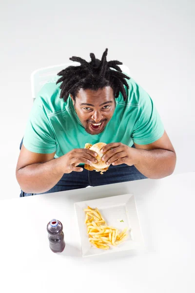 Overweight african american man eating hamburger — Stock Photo, Image