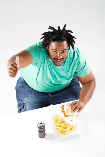Зайва вага афроамериканський чоловік їсть гамбургер — стокове фото