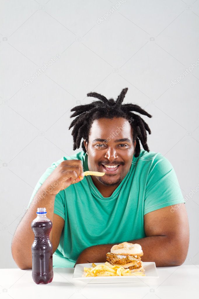 Fat african american man eating chips