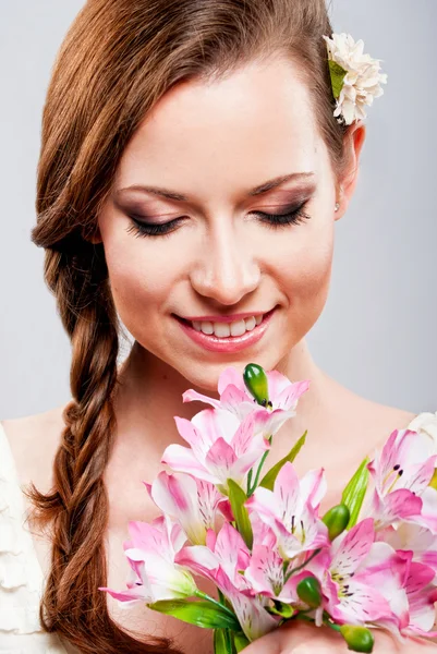 Bela jovem com um buquê de flores — Fotografia de Stock