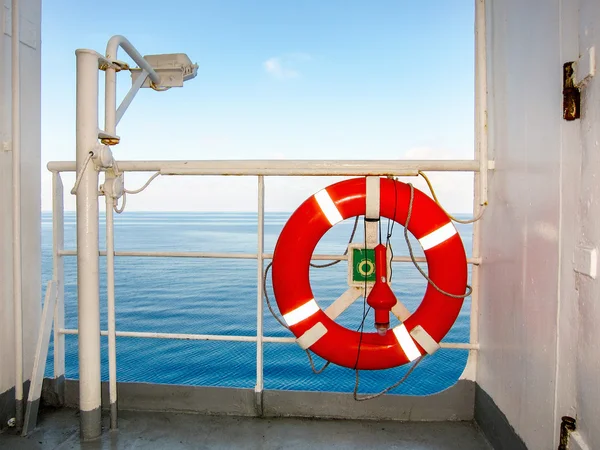 Red life buoy on the rail of a liner