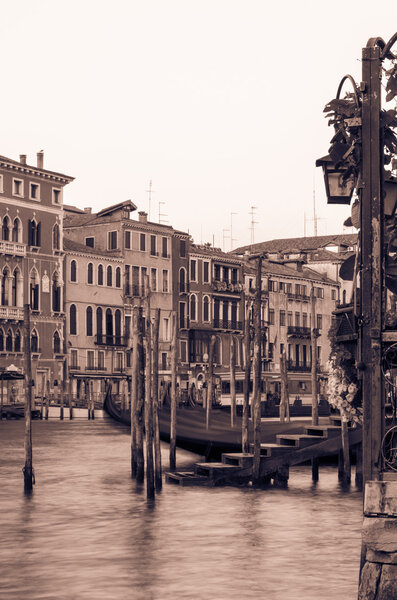 Artistically toned canal scene in Venice with a gondola and beautiful old buildings and architecture lining the waterway