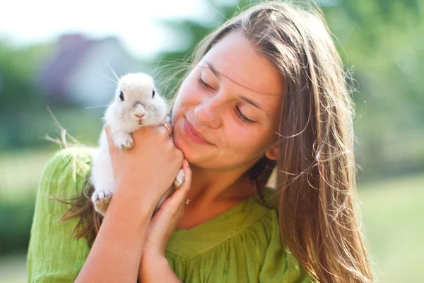 Ragazza felice con un coniglio tra le braccia — Foto Stock