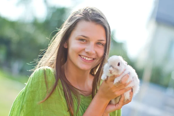 Счастливая девушка с кроликом в руках — стоковое фото