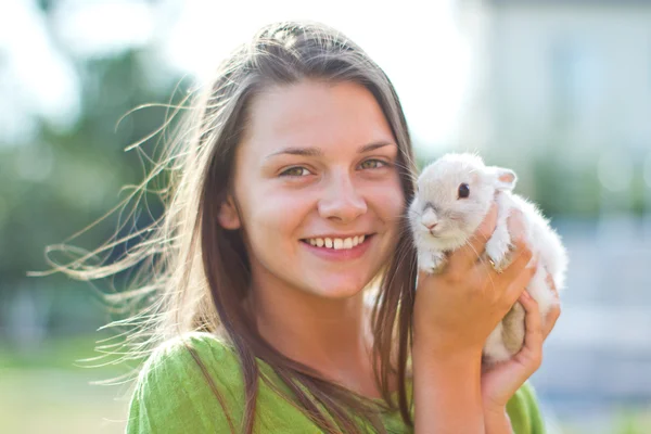 Happy girl with a rabbit in her arms — Stock Photo, Image