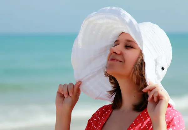 Ung flicka i en vit hatt på havet — Stockfoto