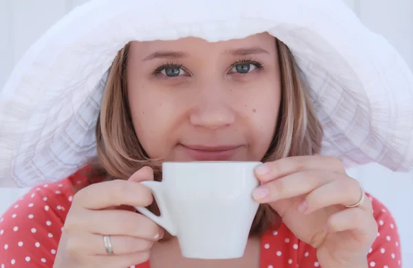 Молода дівчина в червоній сукні з чашкою кави — стокове фото