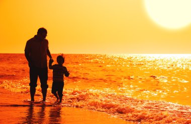 Çocuğun babası deniz günbatımı üzerinde