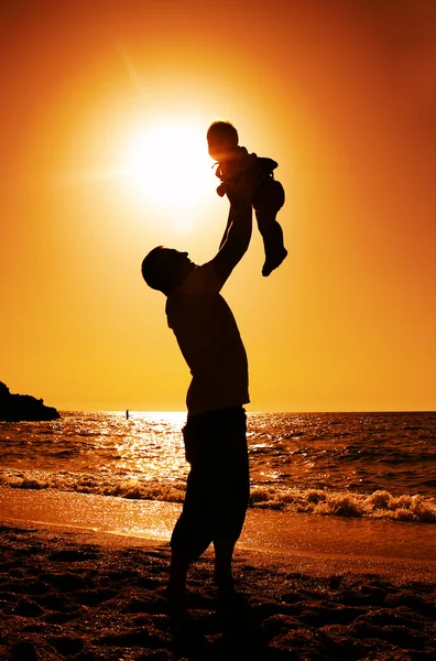 Otec a dcera hraje na pláži při západu slunce — Stock fotografie