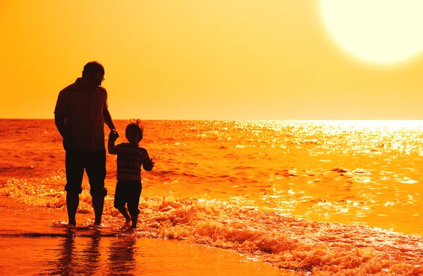 Niño con su padre en el mar al atardecer — Foto de Stock