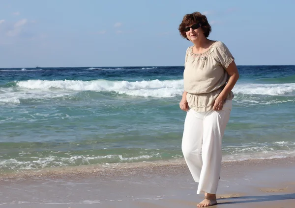 Gelukkig senior vrouw op het strand — Stockfoto