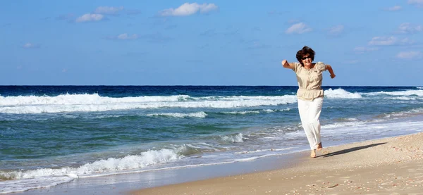 Mulher sênior feliz na praia — Fotografia de Stock