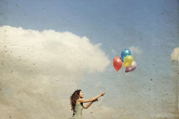 Mladá žena s barevnými balónky — Stock fotografie