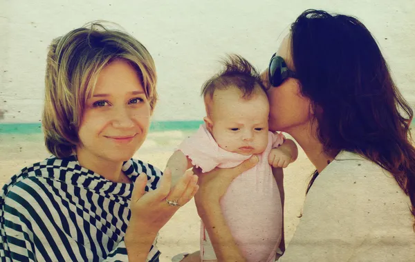 Dos hermosas chicas con un bebé en la playa —  Fotos de Stock
