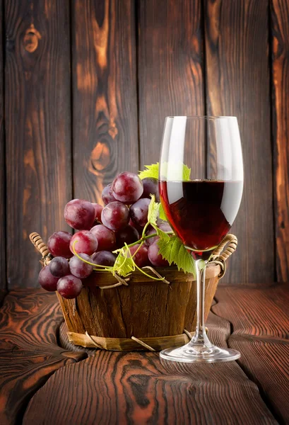Wine glass and grapes in a basket — Stock Photo, Image