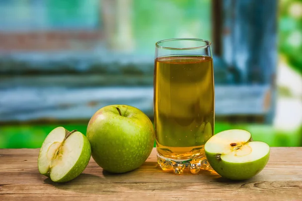 Apple juice in a glass on a table — Stock Photo, Image