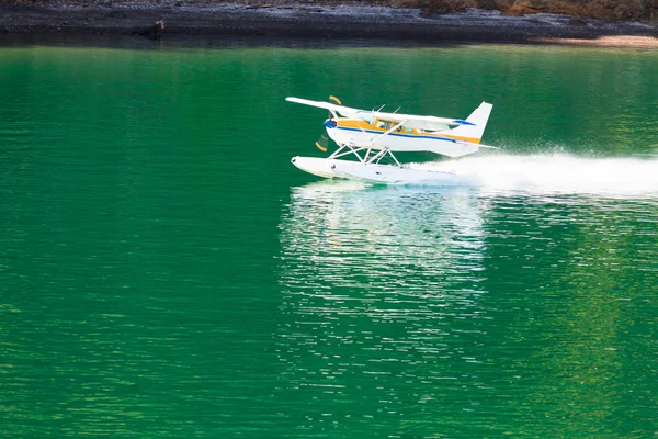 Самолет взлетает на спокойной воде озера — стоковое фото