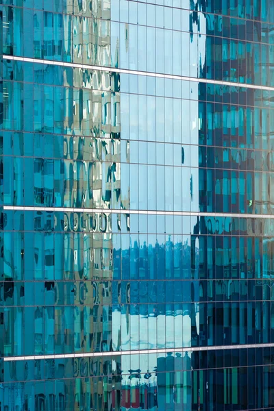 Reflections in modern glass-walled building facade — Stock Photo, Image
