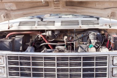 Open hood of old van shows engine and front grille clipart